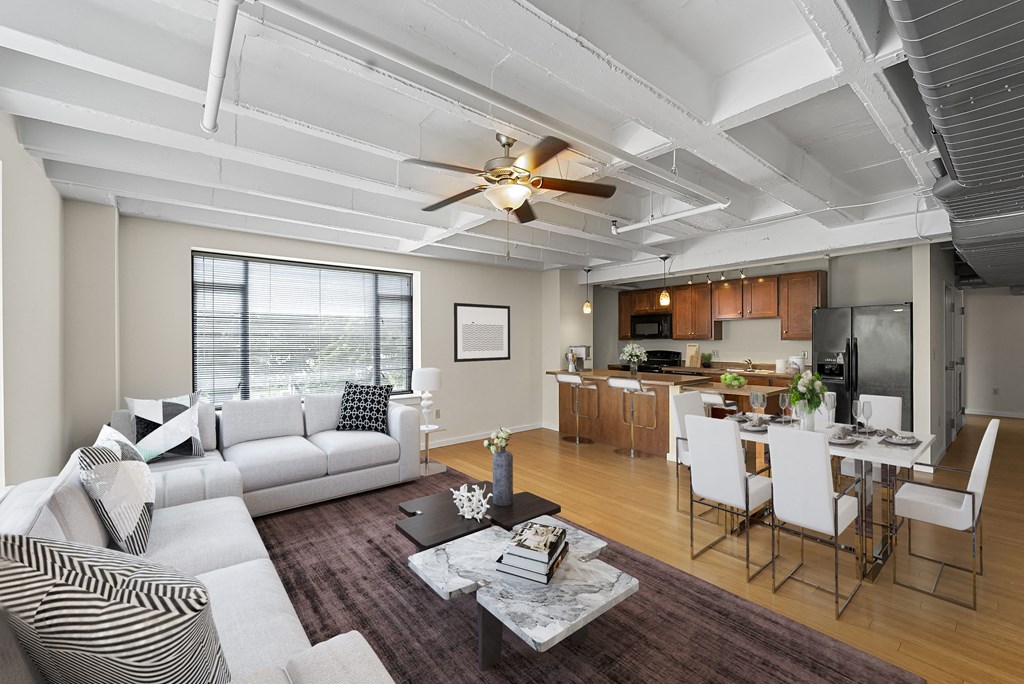 a living room with a couch and a table in front of a kitchen
