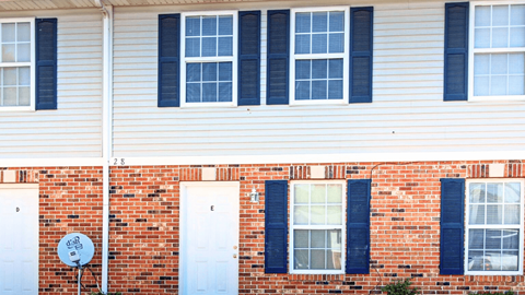 A red brick house with white doors and windows.
