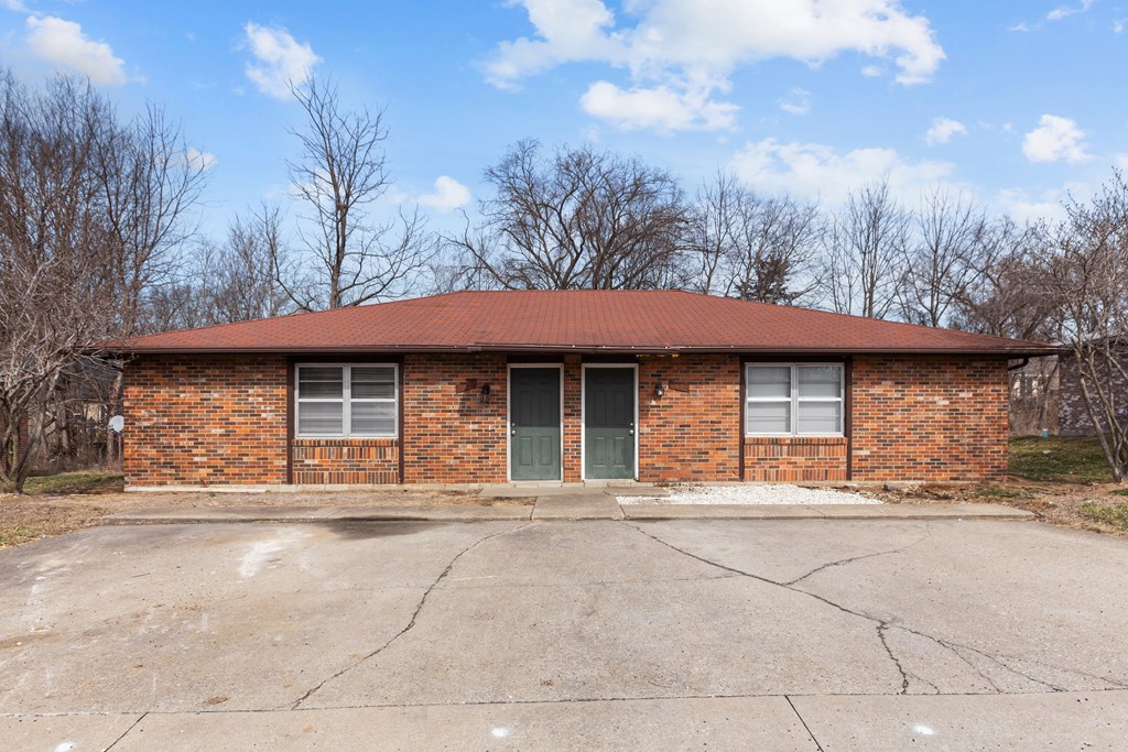 the front of a brick building with a red roof