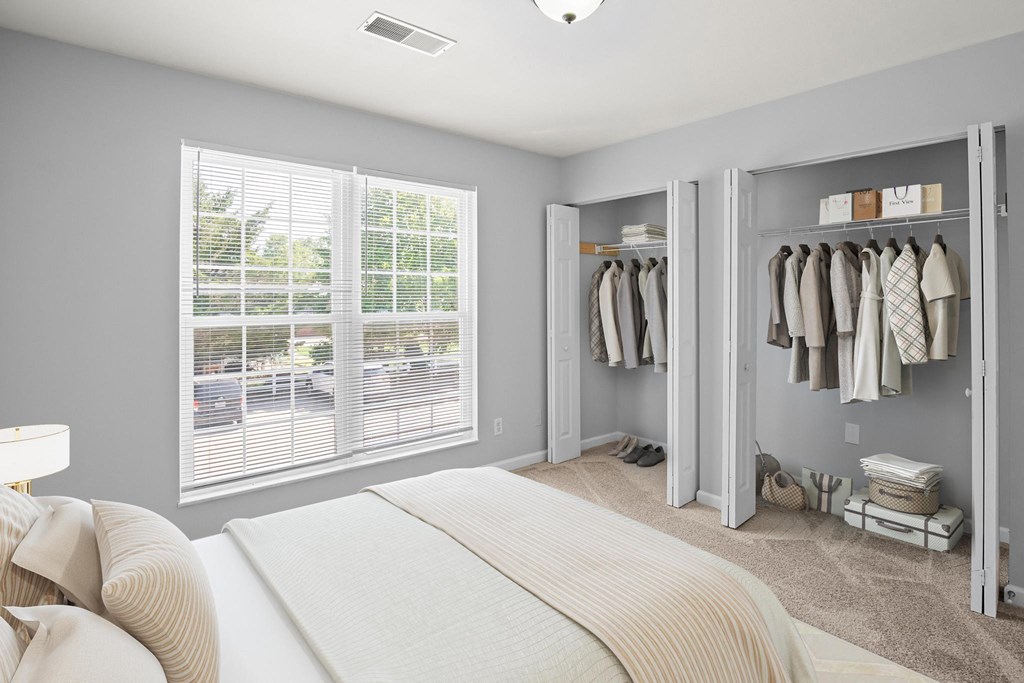 a bedroom with a large window and a closet with two doors