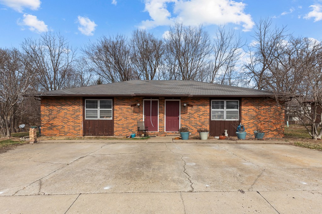the front of a brick house with a driveway