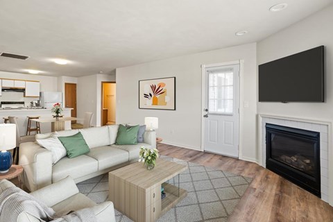 A living room with a white couch and a fireplace.