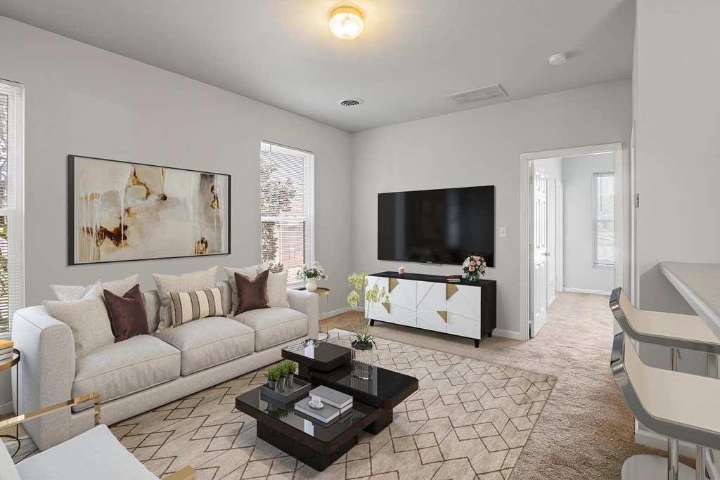 a living room with a couch coffee table and a tv on the wall