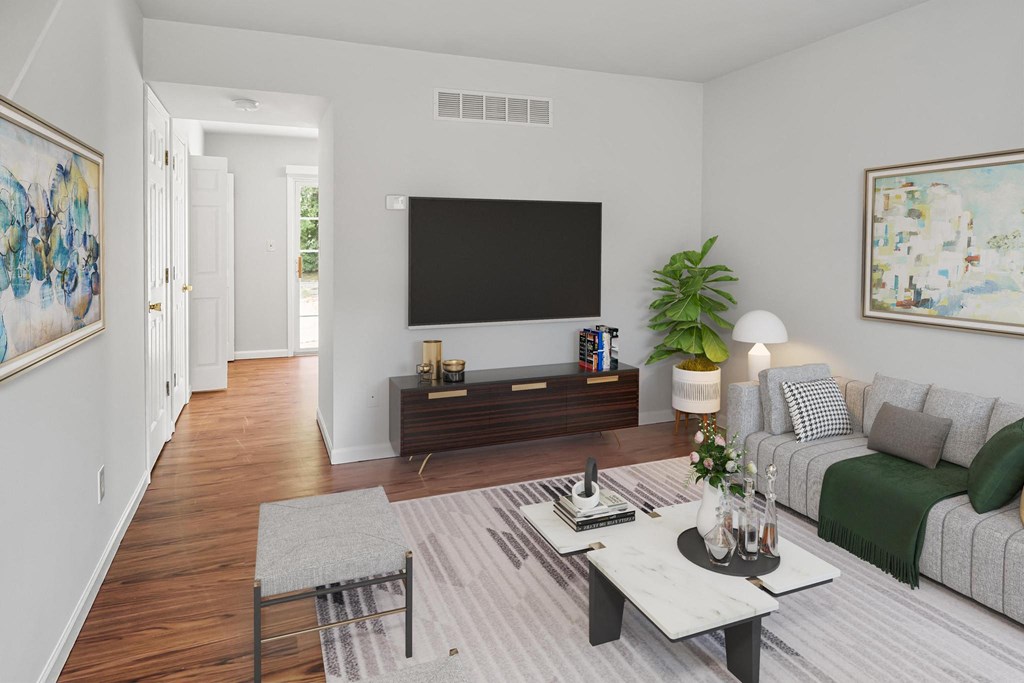 a living room with a couch coffee table and a tv on the wall