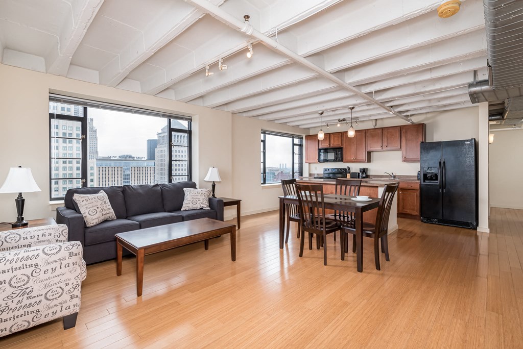 a living room with a leather couch and a dining room table