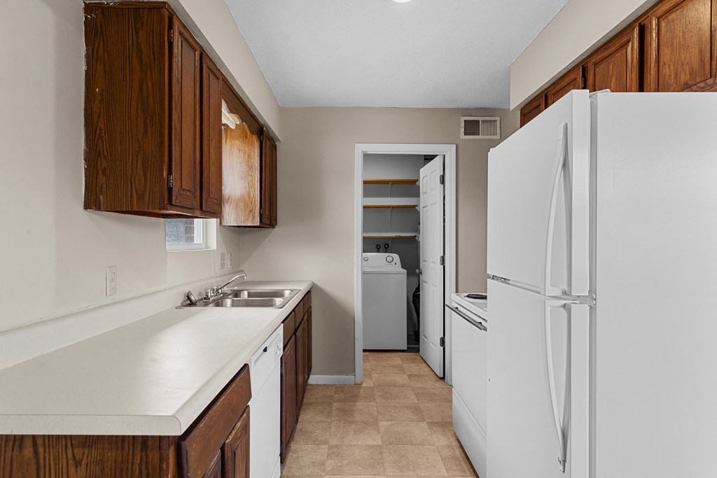 a kitchen with white appliances and wooden cabinets and a white refrigerator