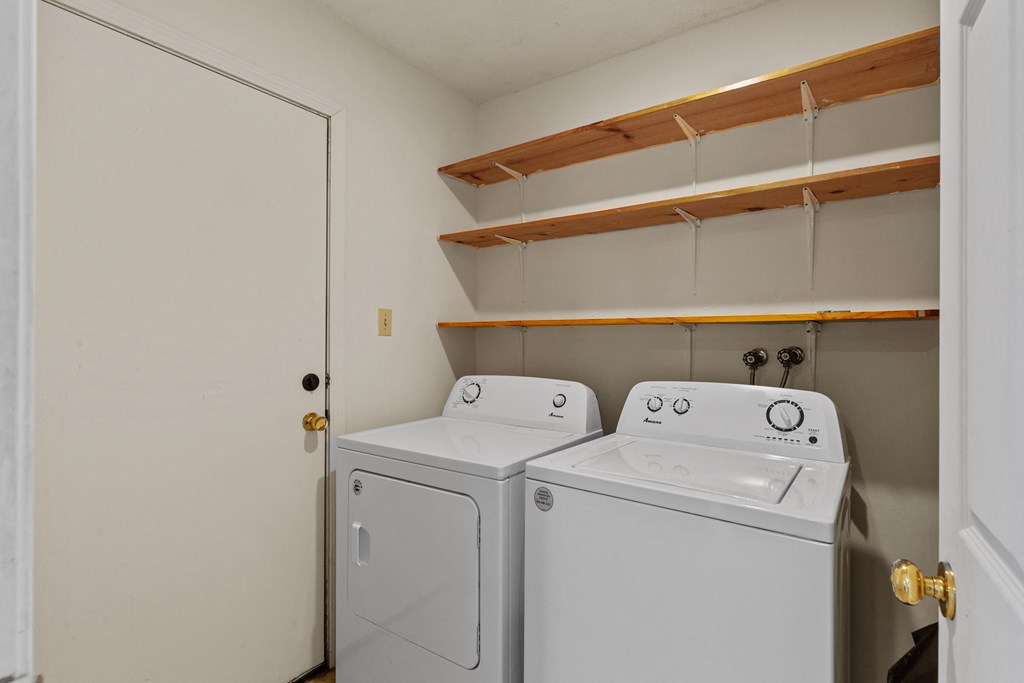 an empty laundry room with two washes and a dryer