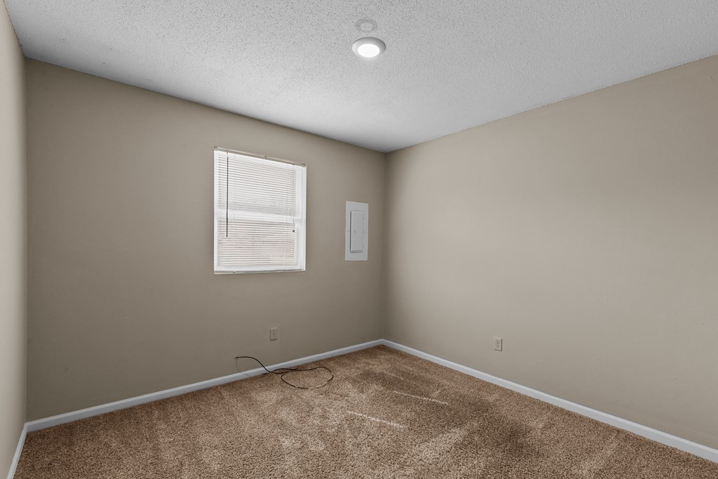 an empty room with carpet and a window