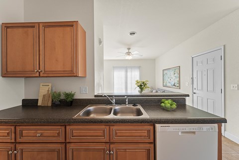 A kitchen with brown cabinets and a white dishwasher.