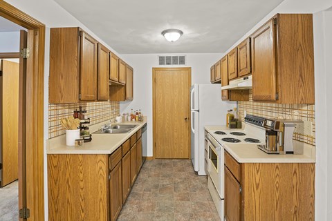 A kitchen with wooden cabinets and a white refrigerator.