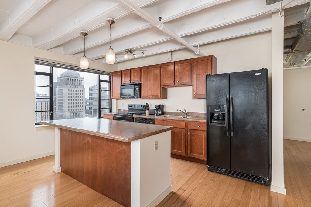 a kitchen with a large island and a black refrigerator