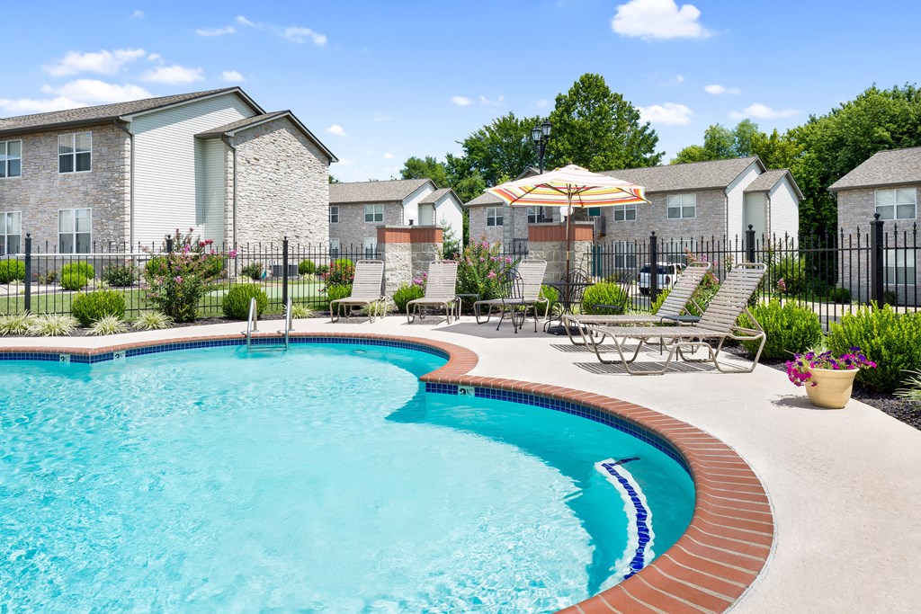 our apartments have a resort style pool with chairs and an umbrella