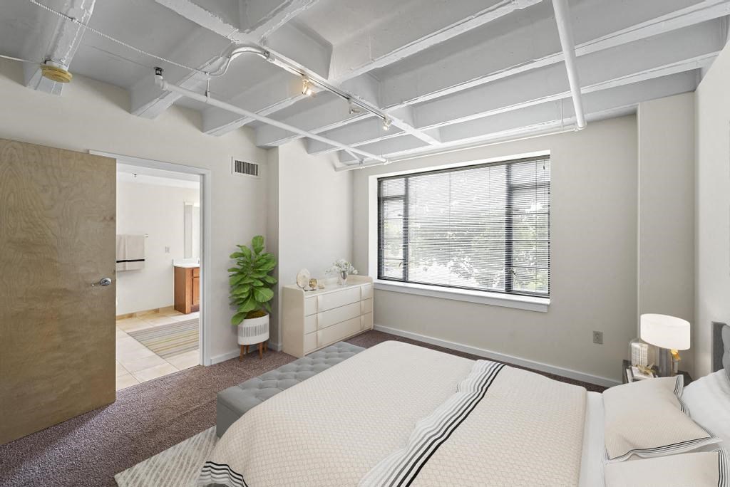 a bedroom with a bed and a large window