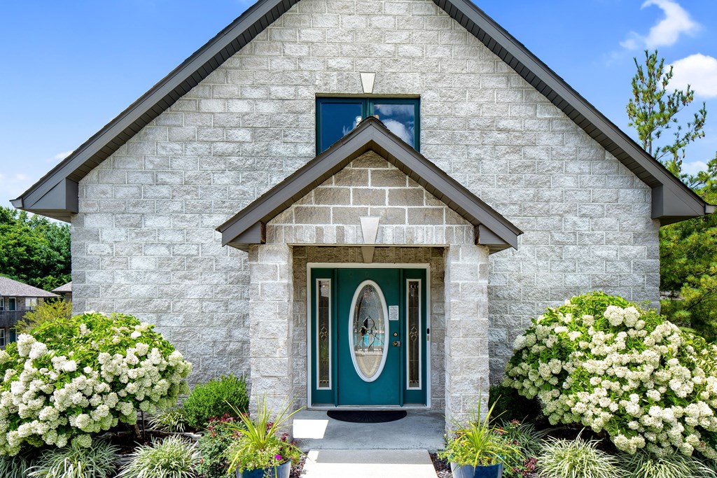 a white brick house with a green door and a window