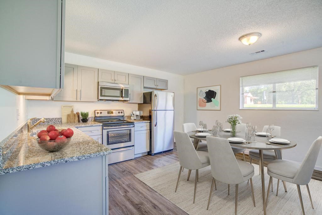 a kitchen and dining room with a table and chairs