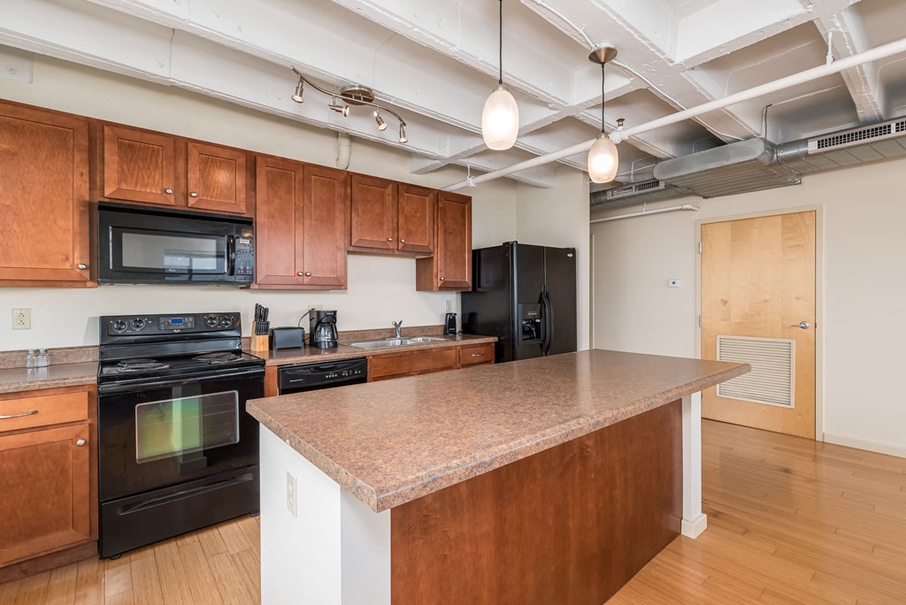 a kitchen with a granite counter top and black appliances