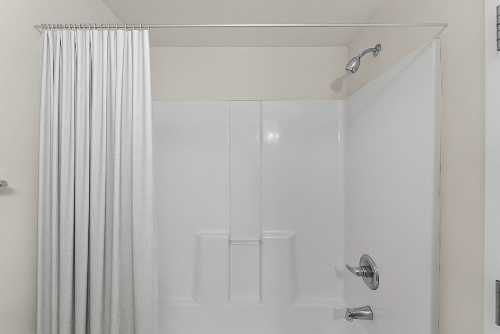 a white shower with a shower curtain in a bathroom