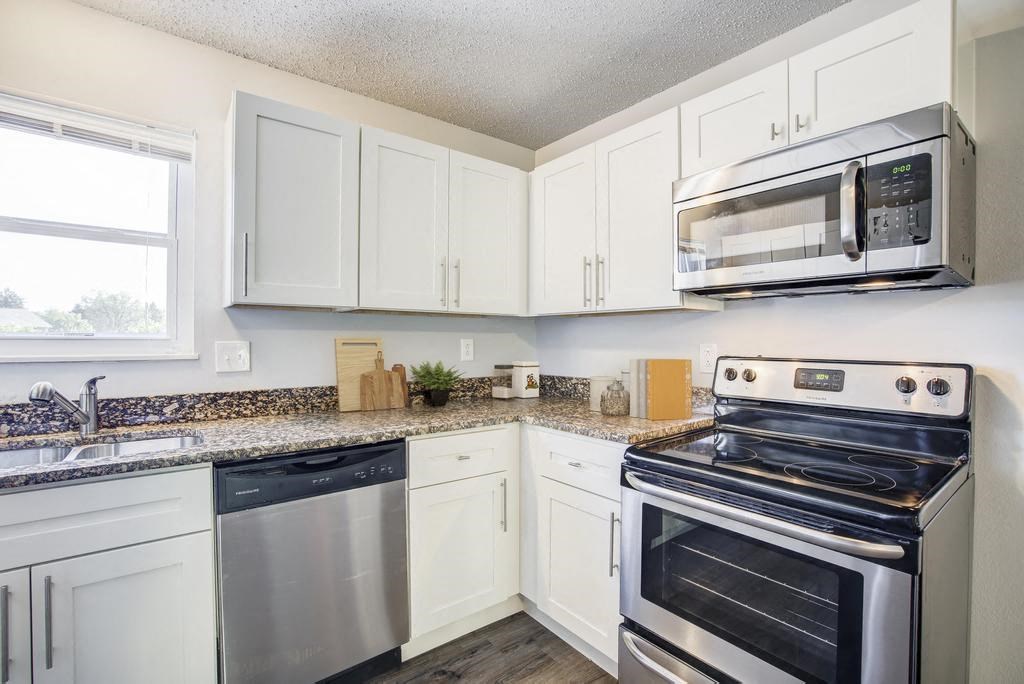 a kitchen with white cabinets and stainless steel appliances