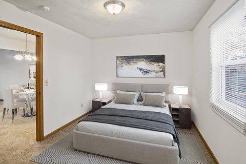 A bedroom with a large bed and a painting on the wall.