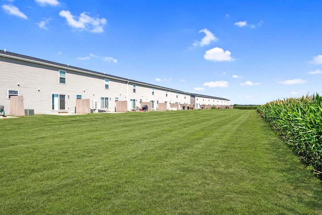 a row of white buildings with a green lawn in front of them