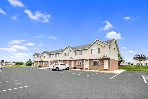 the view of a residence with a car parked in a parking lot