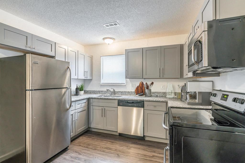 a kitchen with a refrigerator freezer and a stove top oven