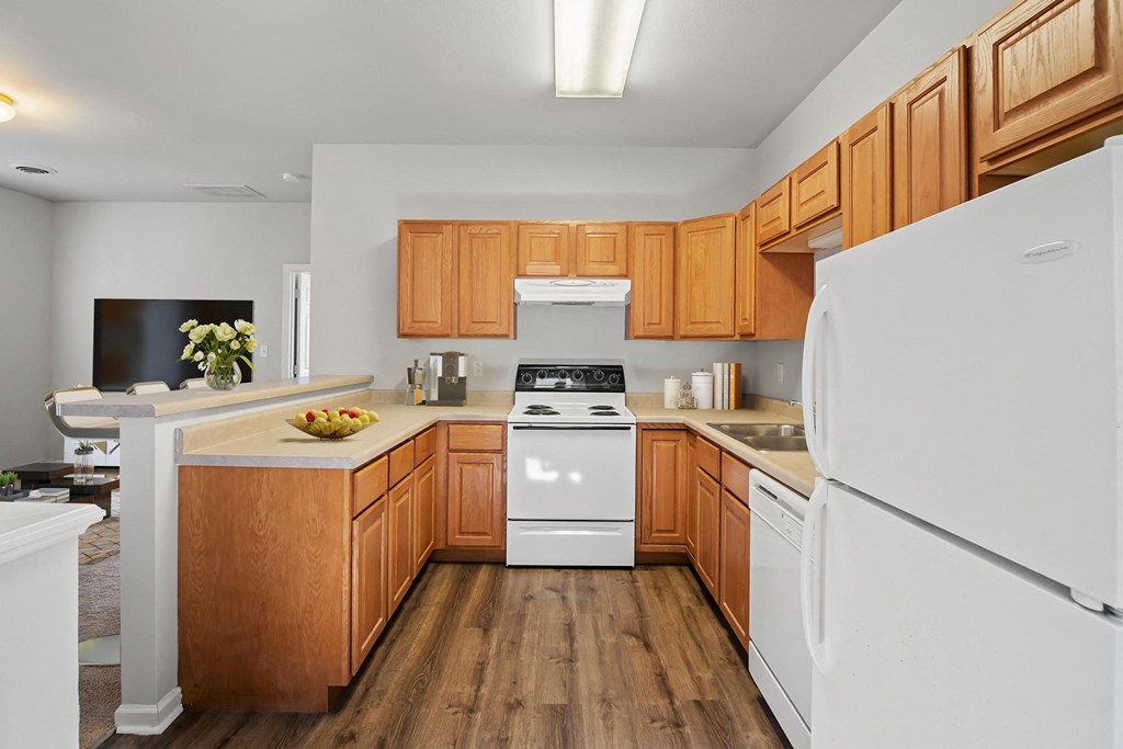 a kitchen with wood cabinets and white appliances