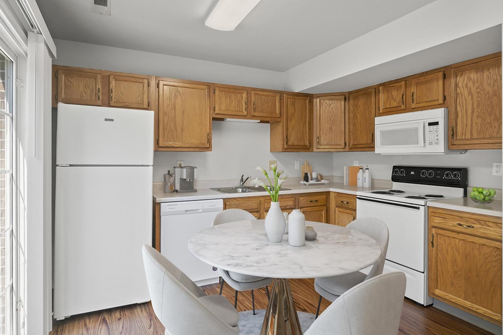 a kitchen with white appliances and wooden cabinets