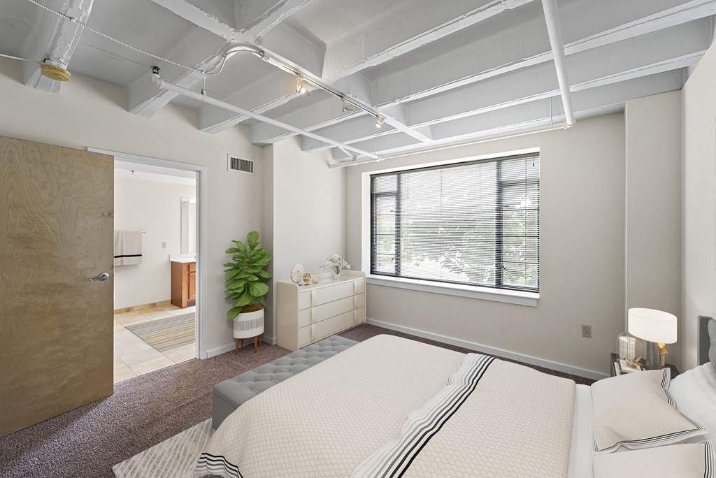 a bedroom with a bed and a window