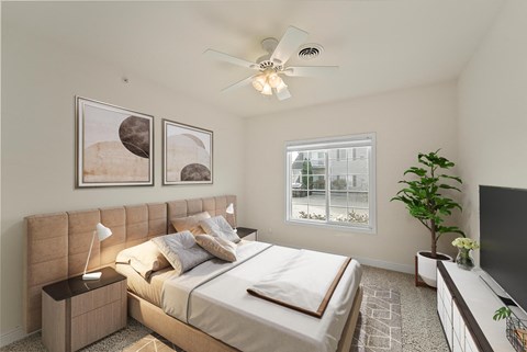 A bedroom with a large bed and a ceiling fan.