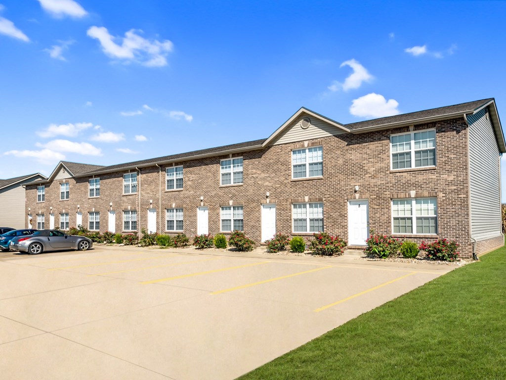 a brick apartment building with cars parked in front of it