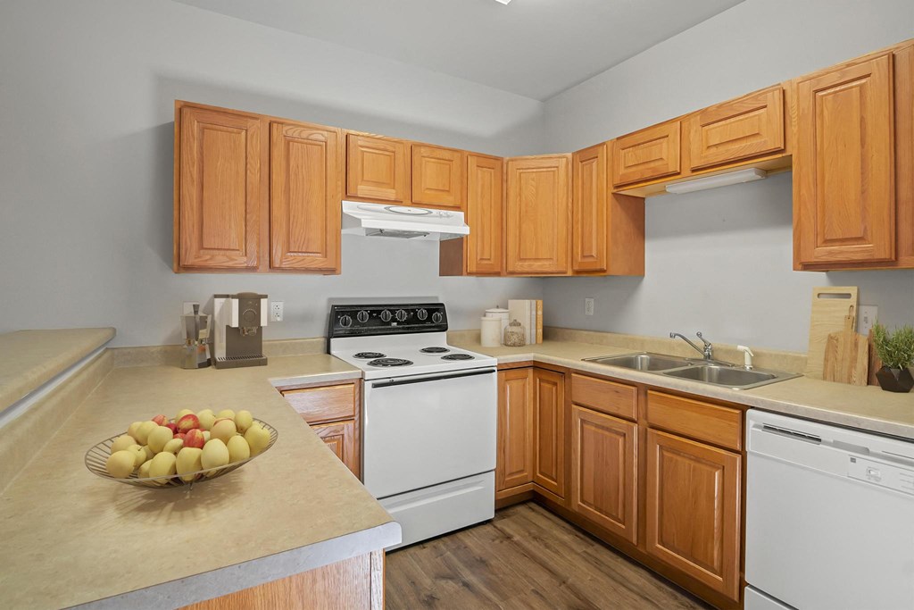 a kitchen with wooden cabinets and a bowl of fruit on the counter