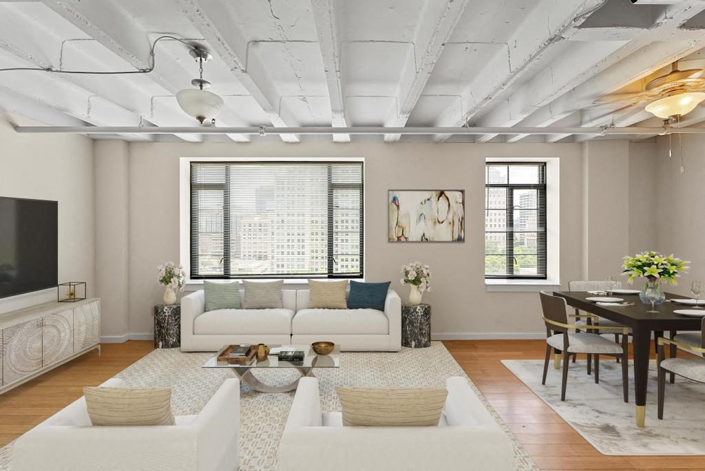 a living area with two couches a table with chairs and a tv on the wall