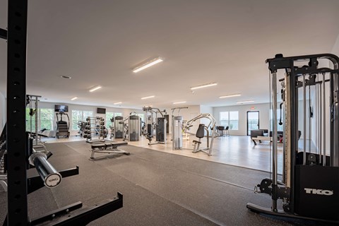 A gym with a variety of equipment including weights and machines.