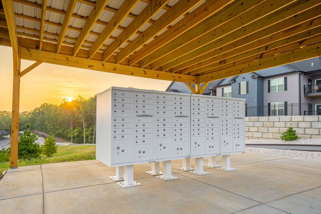 A large white structure with multiple compartments is situated under a wooden roof.