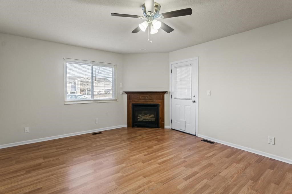 A room with a fireplace and a ceiling fan.