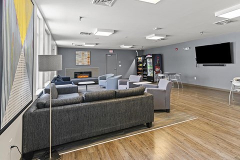 A modern living room with a grey sofa and a wooden floor.