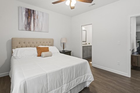 A bedroom with a large bed and a painting on the wall.