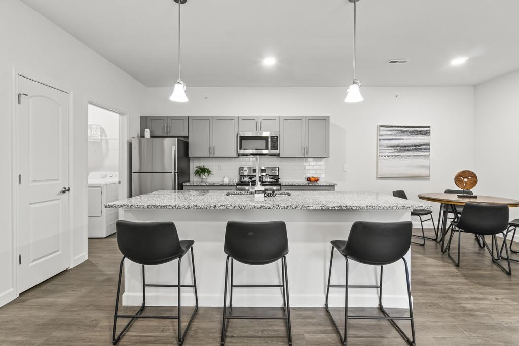 A kitchen with a bar area and chairs.
