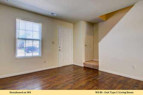 A living room with a wooden floor and white walls.