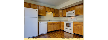 A kitchen with wooden cabinets and white appliances.