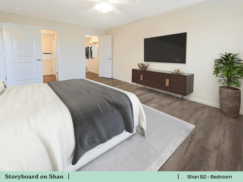 a bedroom with a bed and a tv on the wall