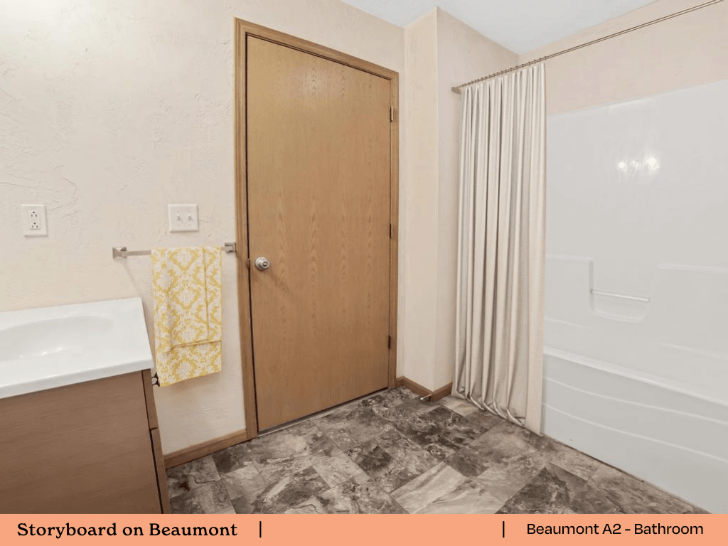 a bathroom with a shower and a sink and a door