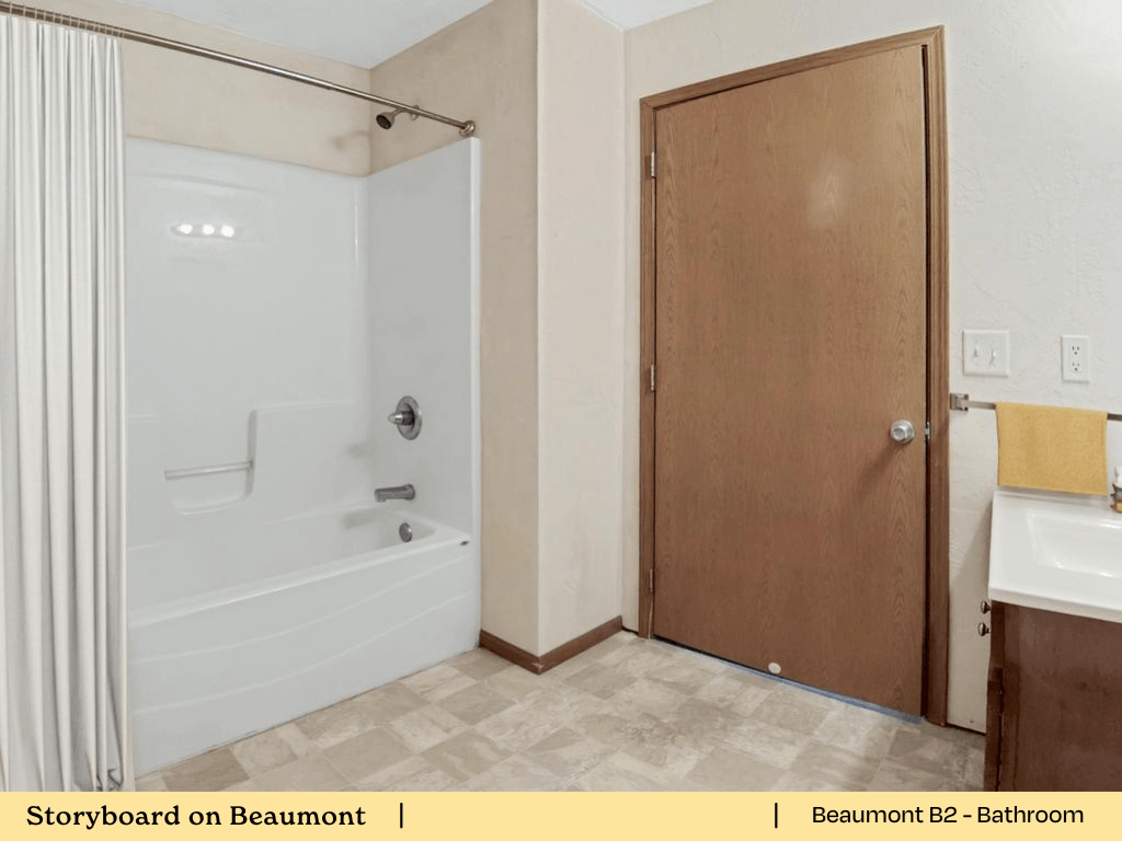 a bathroom with a shower and a sink and a wooden door