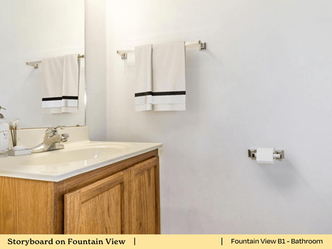 a bathroom with a sink and two towels and a mirror