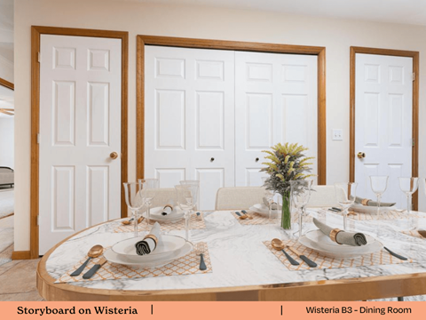 a dining room with white doors and a table with plates and silverware