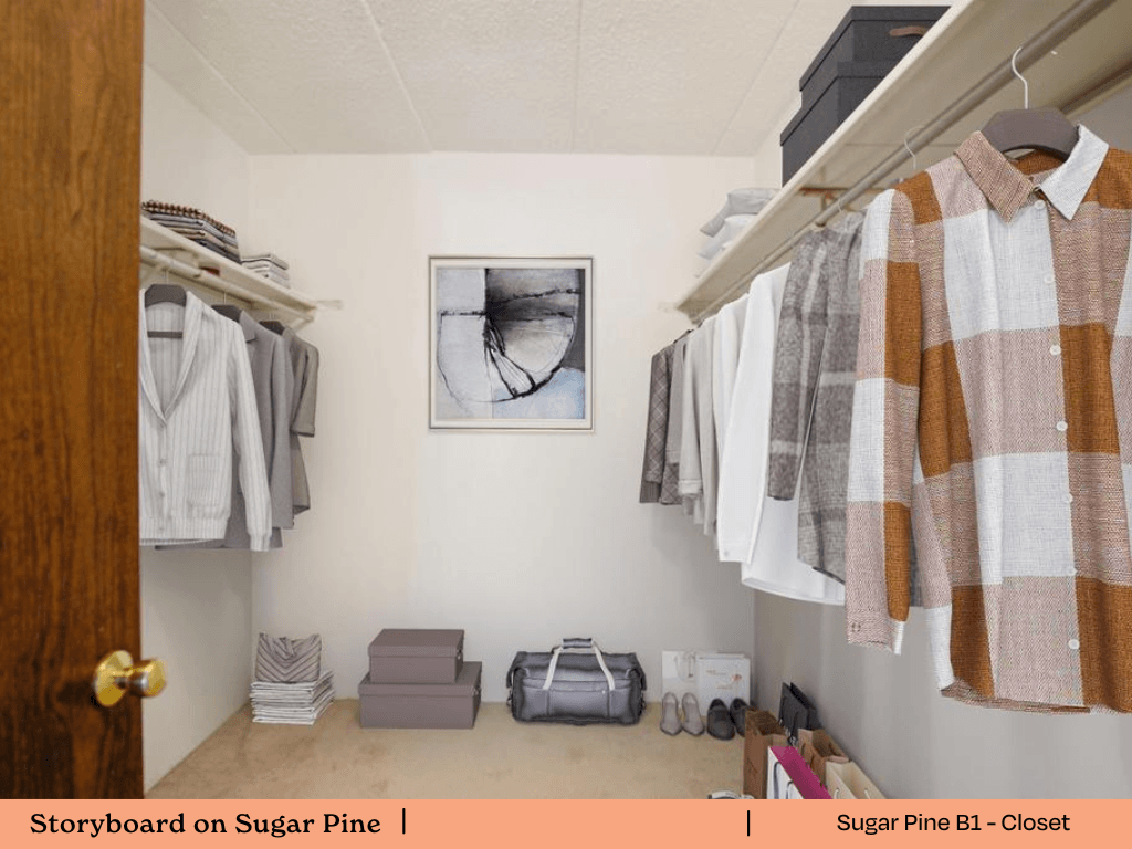 a walk in closet with clothes hanging on a rack and a door to a closet