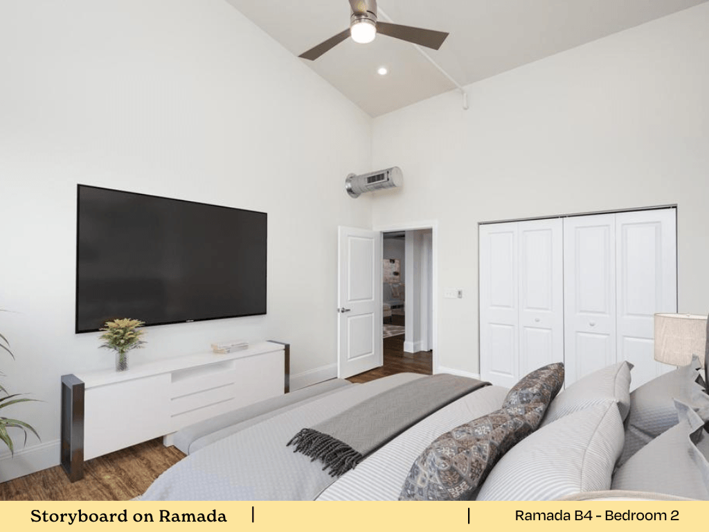 a bedroom with a bed and a tv on the wall