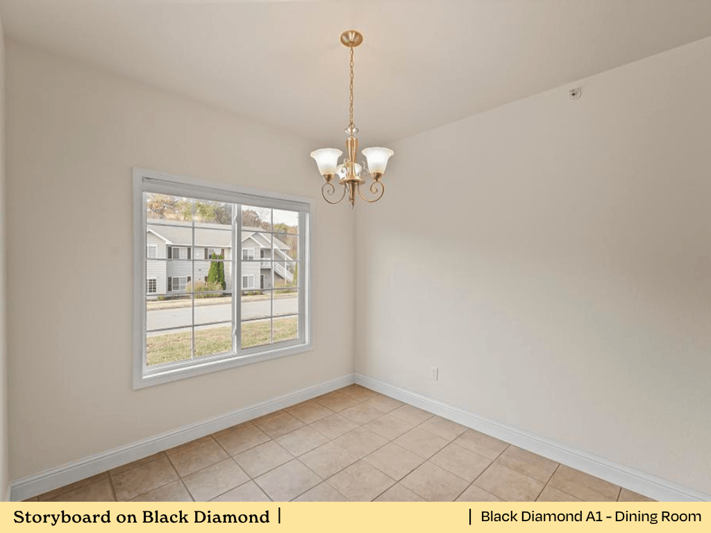 an empty living room with a window and a chandelier