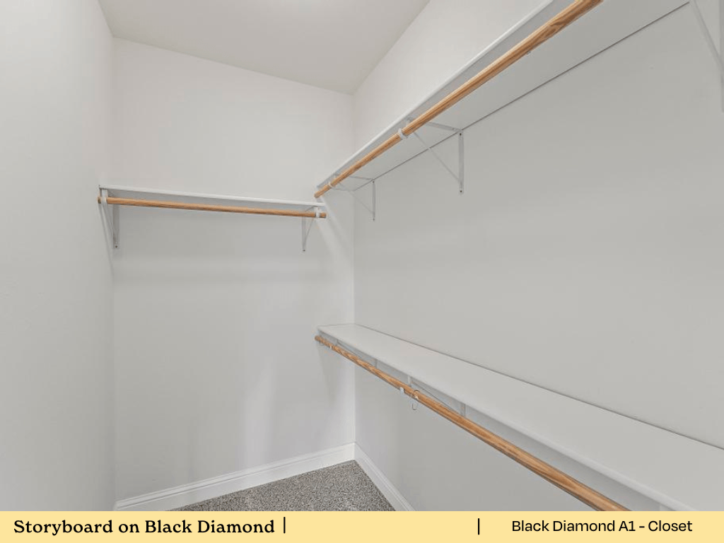 a walk in closet with white walls and wooden shelves